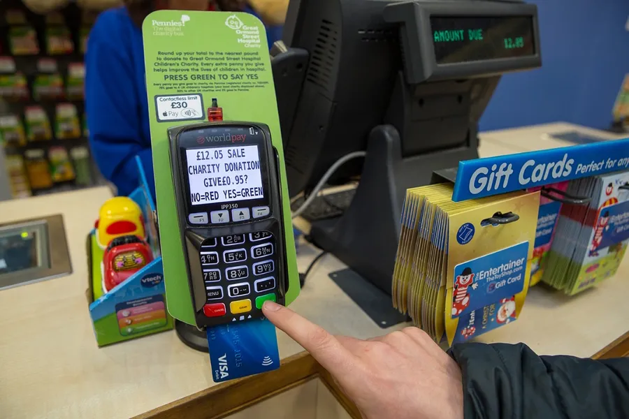 Shopper at a British supermarket till being asked to donate 20p to charity on the card terminal