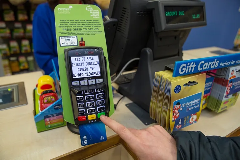 Shopper at a British supermarket till being asked to donate 20p to charity on the card terminal
